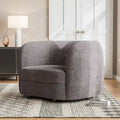 Fauteuil de style moderne doté d'accoudoirs incurvés, d'un coussin d'assise en forme de haricot et de pieds ronds en bois, recouvert d'un tissu bouclé.