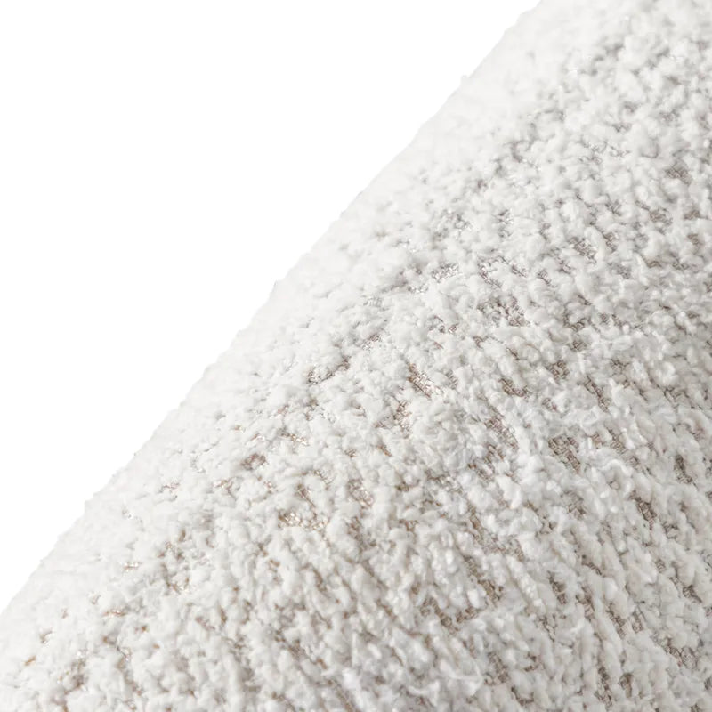 Fauteuil de style moderne doté d'accoudoirs incurvés, d'un coussin d'assise en forme de haricot et de pieds ronds en bois, recouvert d'un tissu bouclé.