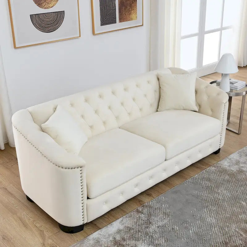 Canapé moderne en velours de 196 cm avec dossier capitonné et accoudoirs ornés de clous décoratifs ; inclut deux coussins décoratifs.
